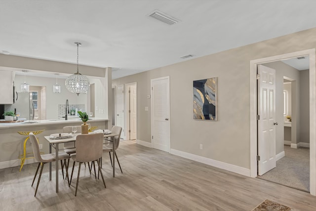 dining space with sink and light hardwood / wood-style flooring