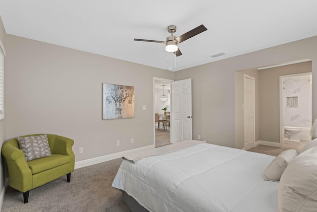 carpeted bedroom with ensuite bathroom and ceiling fan