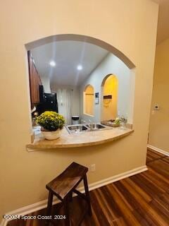 kitchen featuring dark wood-type flooring and vaulted ceiling