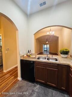 bar featuring sink, black dishwasher, dark hardwood / wood-style floors, a notable chandelier, and dark brown cabinets