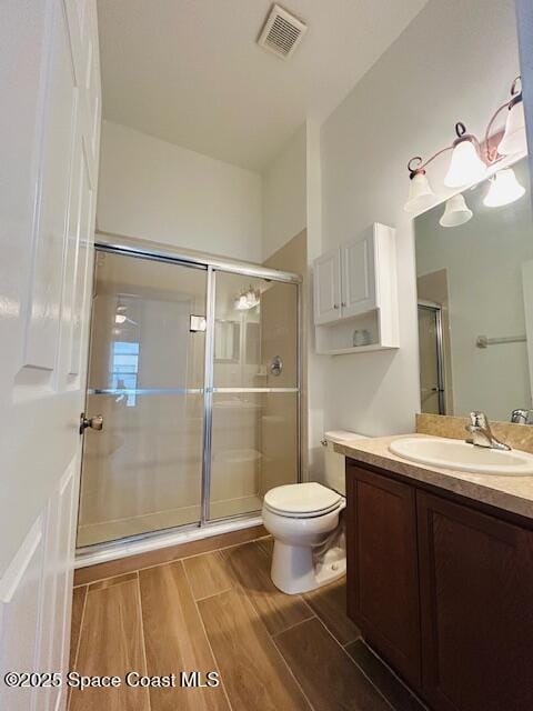 full bath with wood finish floors, visible vents, toilet, and a stall shower