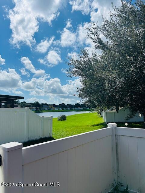 view of patio with fence and a water view