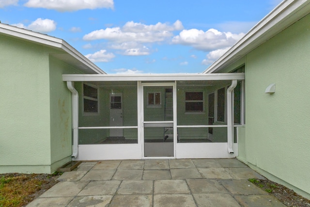 view of exterior entry featuring a patio