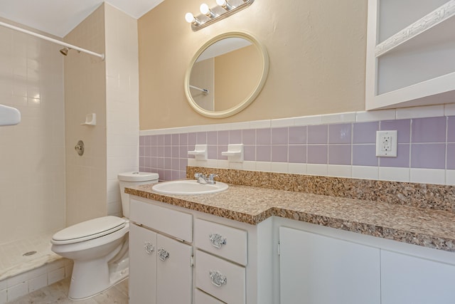 bathroom featuring vanity, tiled shower, tile walls, decorative backsplash, and toilet