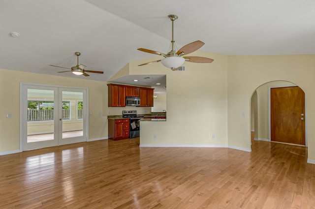 unfurnished living room with hardwood / wood-style flooring, high vaulted ceiling, and ceiling fan