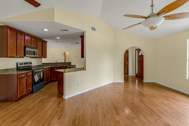 kitchen with appliances with stainless steel finishes, kitchen peninsula, ceiling fan, and light hardwood / wood-style flooring