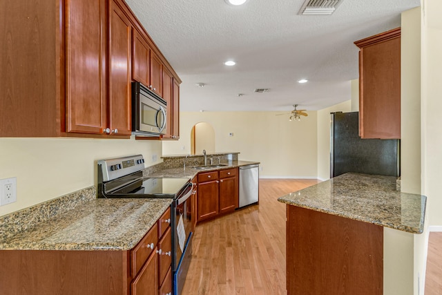 kitchen with ceiling fan, light hardwood / wood-style floors, appliances with stainless steel finishes, and kitchen peninsula