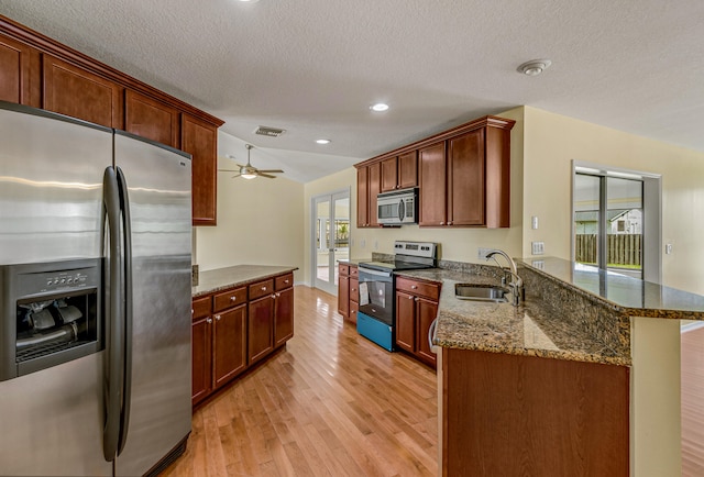 kitchen with ceiling fan, light wood-type flooring, sink, appliances with stainless steel finishes, and kitchen peninsula