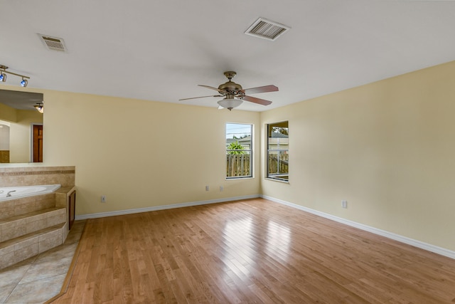 unfurnished room with light wood-type flooring and ceiling fan