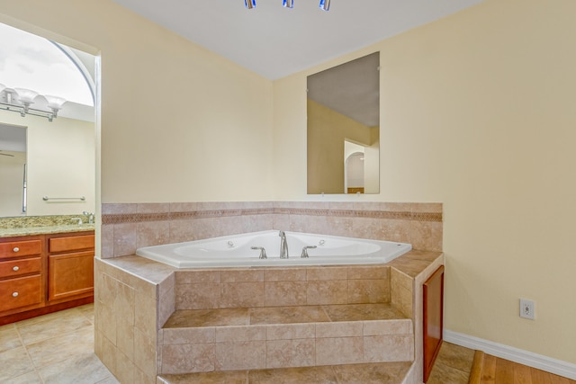 bathroom with tiled tub, tile patterned floors, and vanity