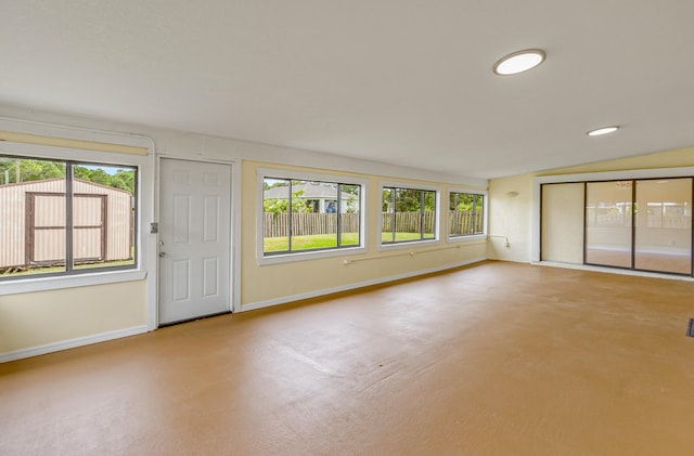 spare room featuring lofted ceiling and plenty of natural light