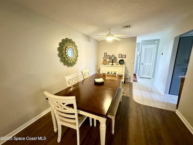 dining space featuring a textured ceiling, ceiling fan, and light wood-type flooring