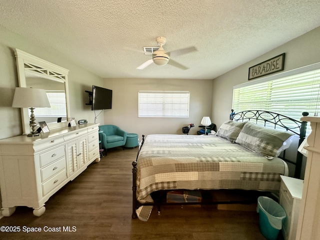 bedroom with dark wood-type flooring, ceiling fan, and a textured ceiling