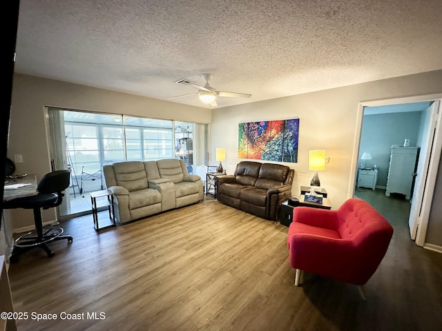 living room with ceiling fan, wood-type flooring, and a textured ceiling