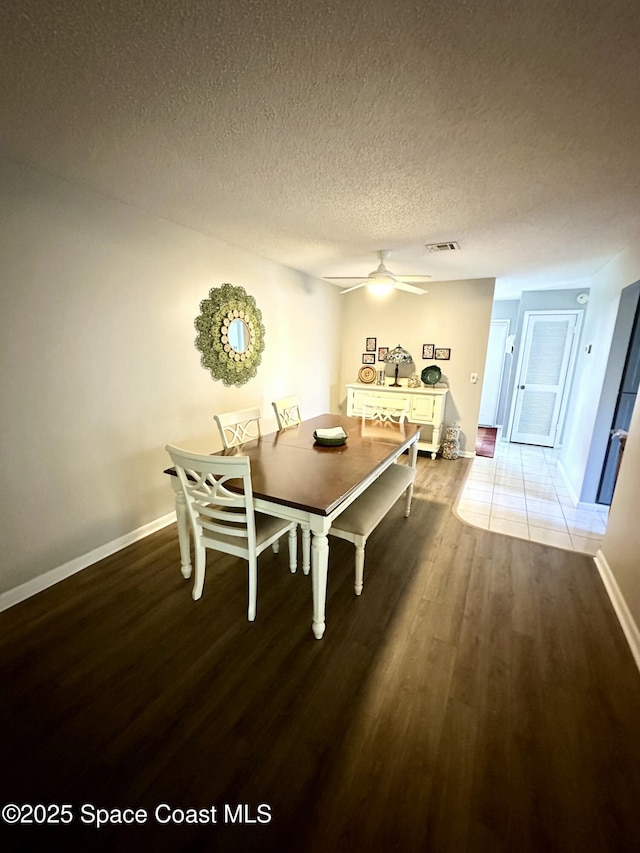 dining space featuring ceiling fan, hardwood / wood-style floors, and a textured ceiling