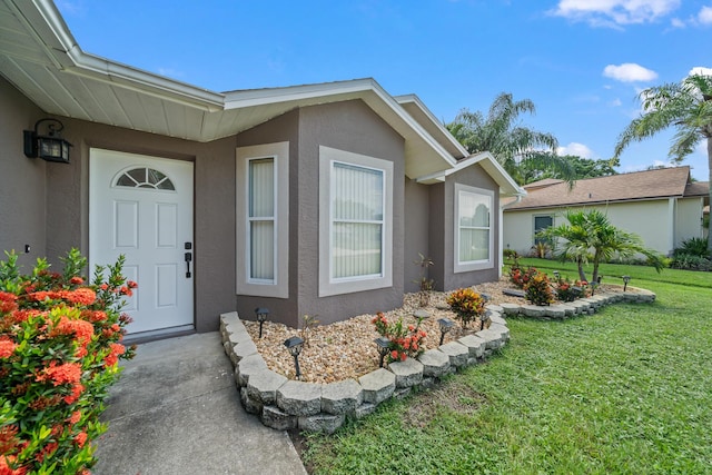 view of exterior entry featuring a yard