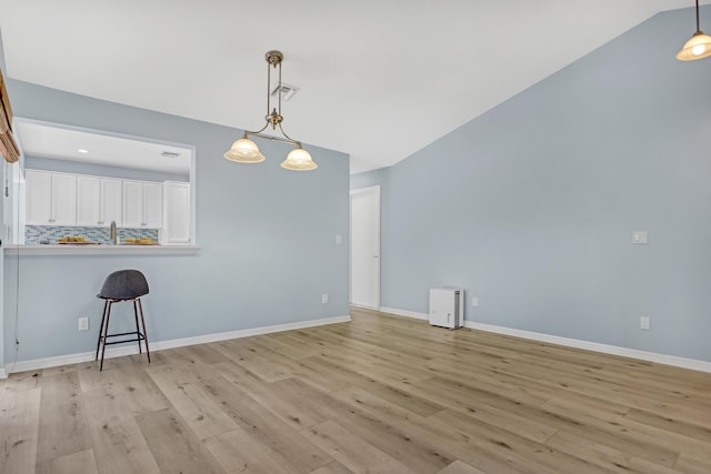 interior space with lofted ceiling and light hardwood / wood-style flooring