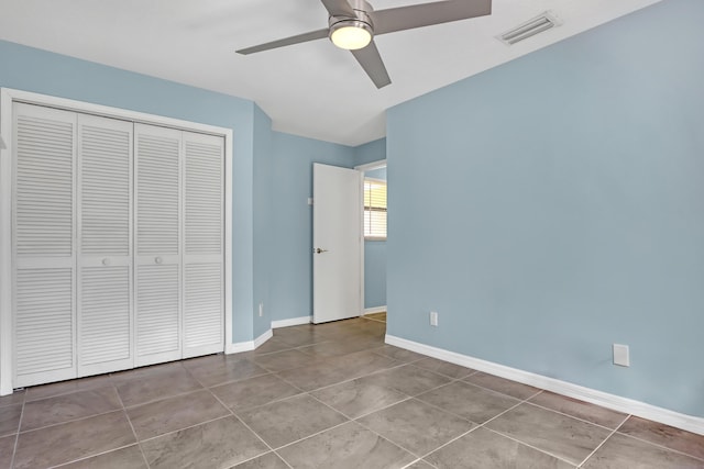 unfurnished bedroom featuring ceiling fan, tile patterned floors, and a closet