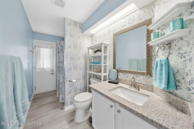 6209 S Mirror Lake Dr Unit 7, Sebastian, FL 32958 - full bathroom with wallpapered walls, wood finished floors, baseboards, vanity, and toilet