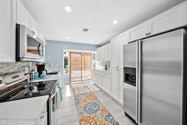 6209 S Mirror Lake Dr Unit 7, Sebastian, FL 32958 - kitchen featuring appliances with stainless steel finishes, a sink, white cabinets, and recessed lighting