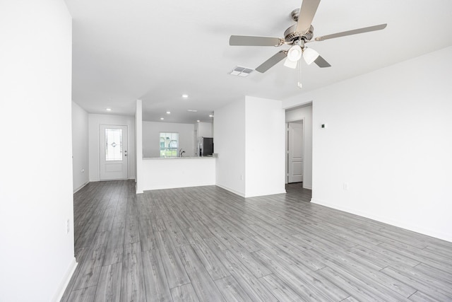 unfurnished living room with sink, light hardwood / wood-style flooring, and ceiling fan