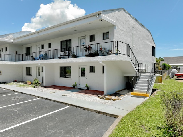 exterior space featuring uncovered parking and stairs