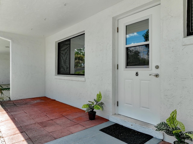 doorway to property featuring stucco siding