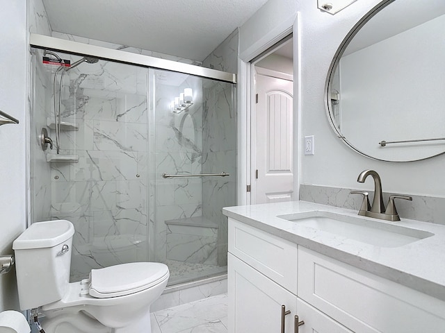 bathroom featuring marble finish floor, a marble finish shower, toilet, vanity, and a textured ceiling