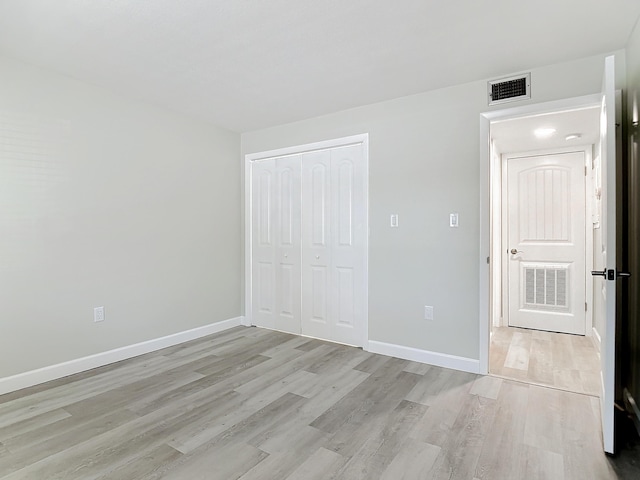 unfurnished bedroom featuring light wood-type flooring, baseboards, and visible vents