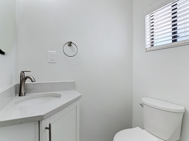 half bathroom featuring toilet and vanity