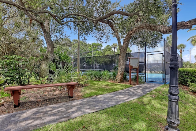 surrounding community with fence, a yard, and a gate