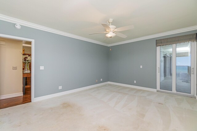 spare room with baseboards, light colored carpet, ceiling fan, and ornamental molding