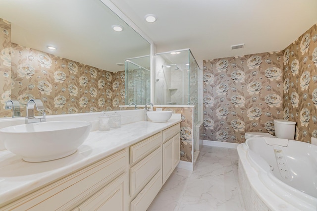 bathroom with wallpapered walls, toilet, a whirlpool tub, and a sink