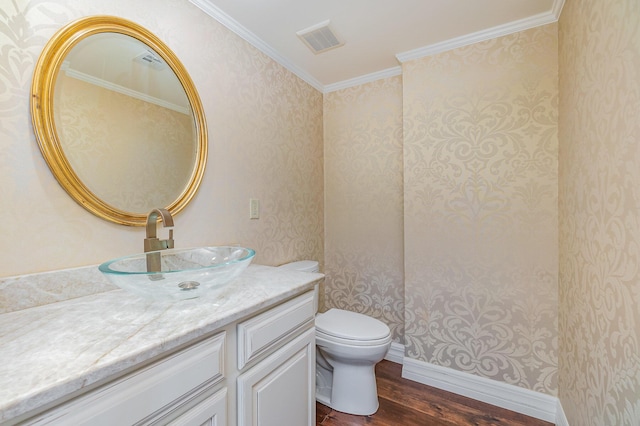 half bath with visible vents, toilet, vanity, and wood finished floors