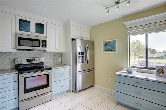 9635 Riverside Dr Unit 3, Sebastian, FL 32958 - kitchen with appliances with stainless steel finishes, white cabinetry, light stone counters, tasteful backsplash, and light tile patterned flooring