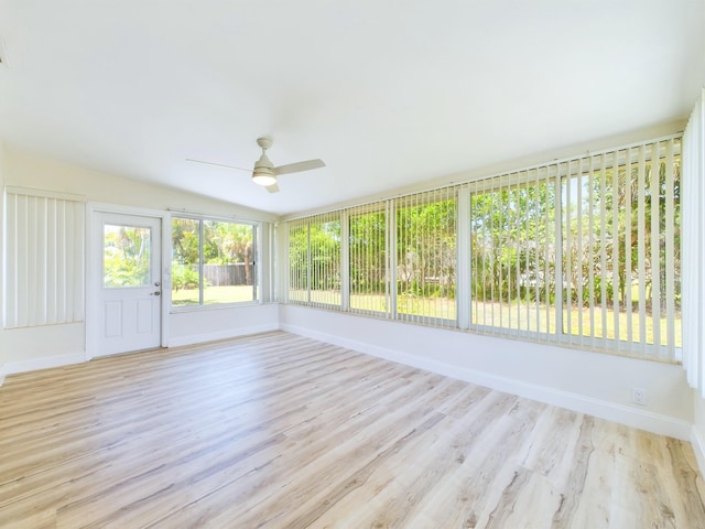 unfurnished sunroom with ceiling fan and vaulted ceiling