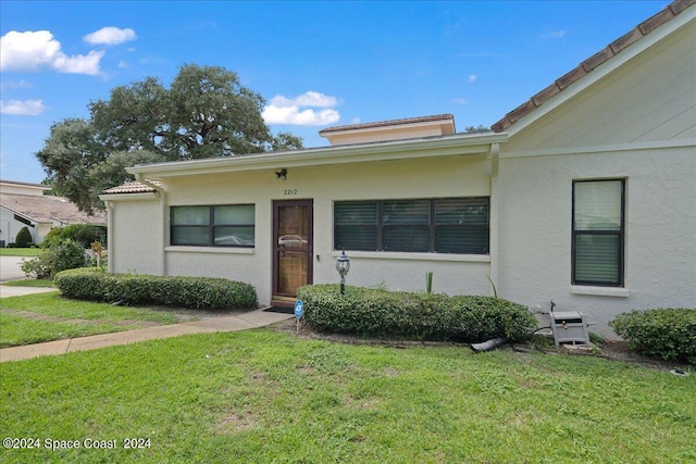 view of front facade with a front yard and stucco siding