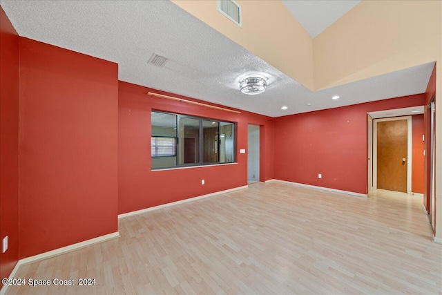 empty room featuring light hardwood / wood-style floors and a textured ceiling