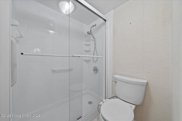 full bath featuring a stall shower and toilet