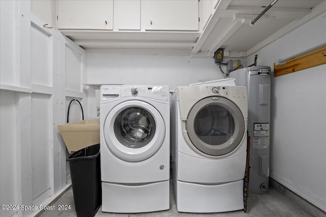 washroom featuring cabinets, electric water heater, and washing machine and clothes dryer