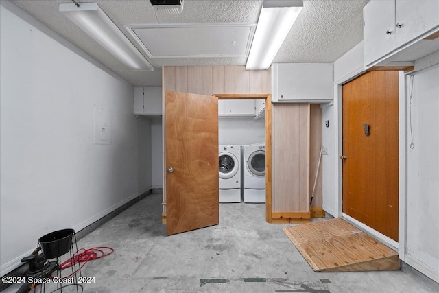 washroom with cabinet space, separate washer and dryer, baseboards, and a textured ceiling