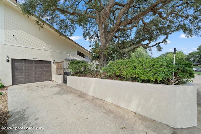 view of property exterior featuring a garage, driveway, and stucco siding