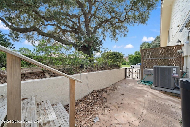 view of patio with fence, central AC, and a gate