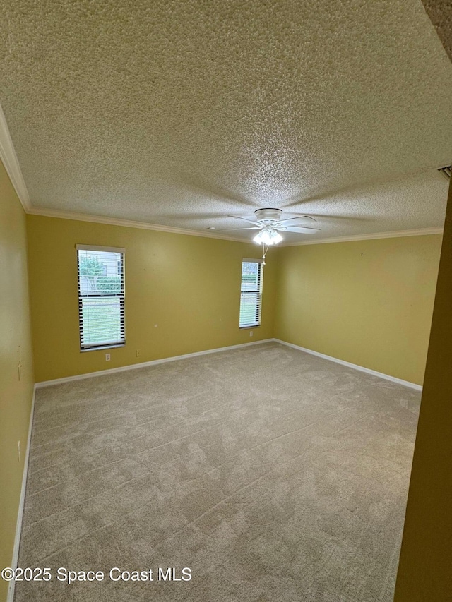 unfurnished room with carpet flooring, a textured ceiling, a wealth of natural light, and ornamental molding