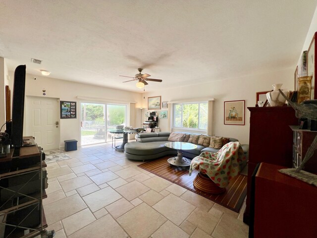 living room with plenty of natural light, light tile patterned flooring, and ceiling fan