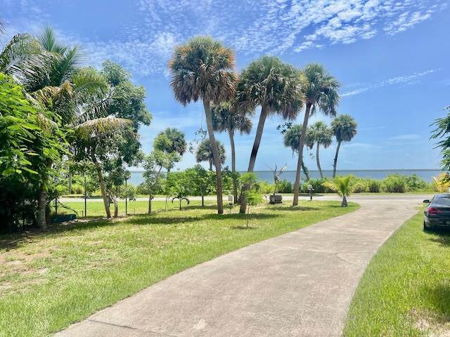 view of property's community with a yard and a water view