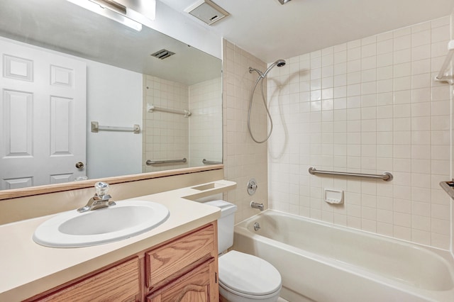 full bathroom featuring vanity, tiled shower / bath combo, and toilet