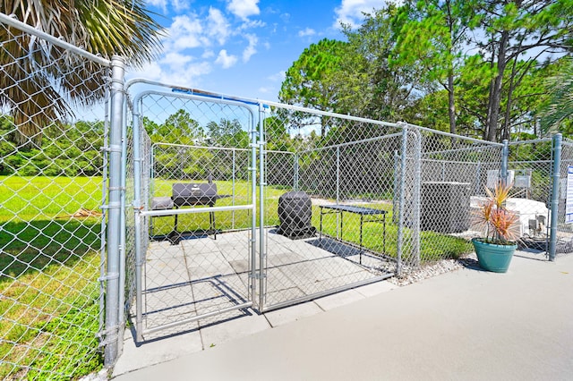 view of gate featuring central AC and a lawn