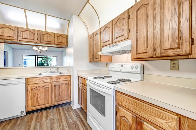 kitchen with sink, an inviting chandelier, wood-type flooring, and white appliances