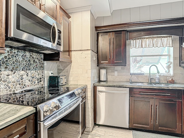 kitchen featuring tasteful backsplash, appliances with stainless steel finishes, sink, and dark brown cabinets